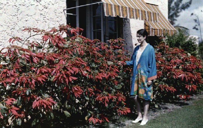 Florida-A-young-woman-stands-by-a-garden-full-of-poinsettias-beside-a-house-Coral-Gables.jpg