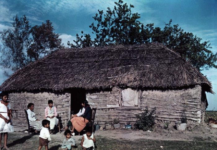 Texas-A-Mexican-family-sits-outside-their-thatch-roof-home-near-Brownsville.jpg