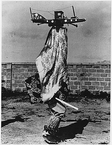 An African in 1944 performs a ritual dance dressed as a P-40 Warhawk..gif