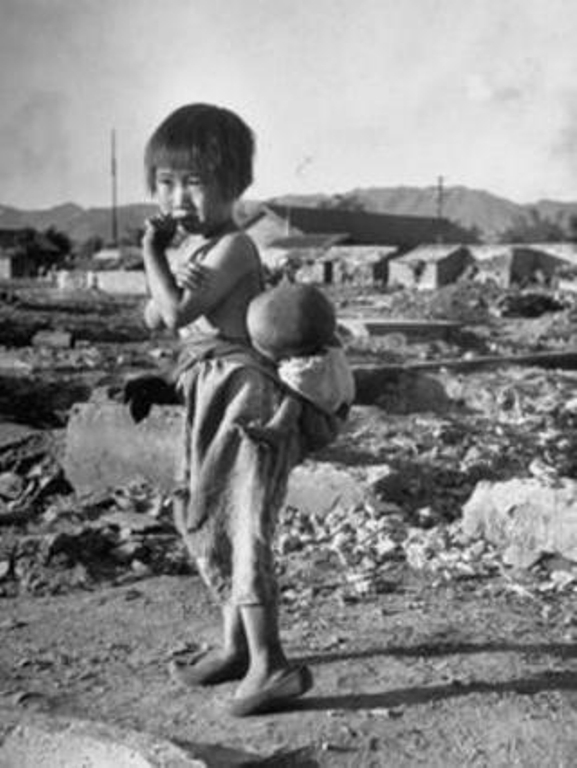 Korean girl with a baby in a sling amid rubble, 1950. Photo by Joseph Scherschel..jpg