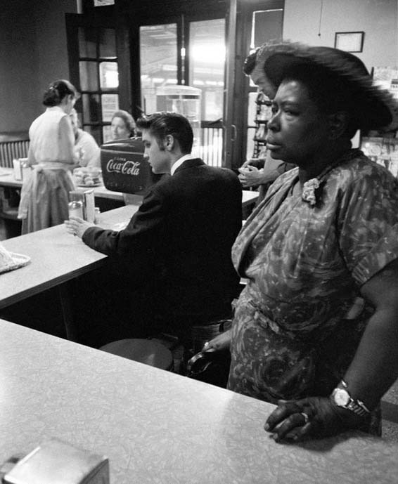 Elvis Presley waits for eggs with Bacon while a black woman waiting for your sandwich. Sit down color is impossible. Tennessee, 1956.jpg