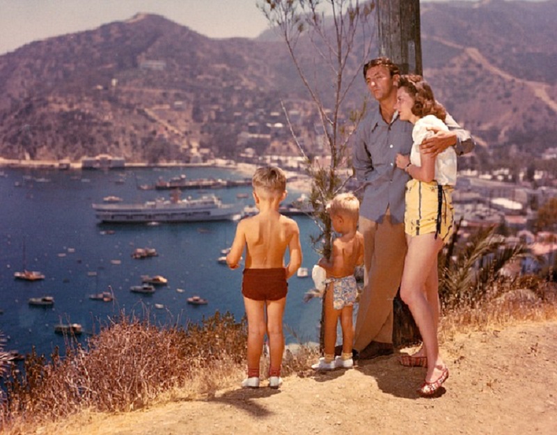 3 James, Chris, Robert Mitchum, and Dorothy watching over the lake and boats below them, 1950s.jpg