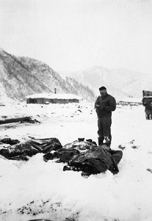 z A_wounded_chaplain_reads_a_memorial_service_over_the_snow-covered_bodies_of_dead_Marines.jpg