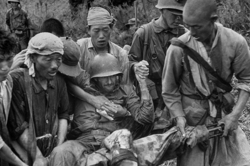 A wounded American Marine is carried on stretcher improvised from a machine gun, Korea 1950.jpg