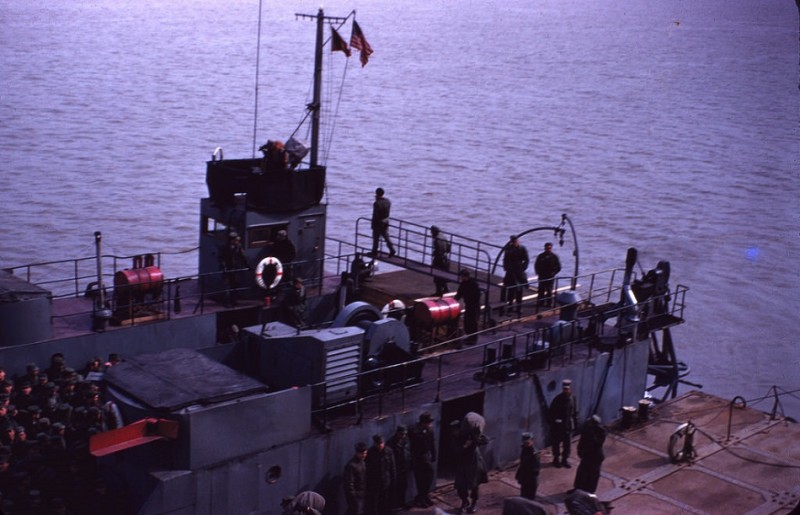 53 GIs getting off LST and boarding our ship, 1955.jpg