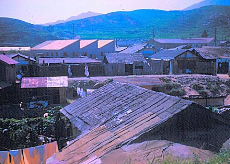 13 HOUSES IN PUSAN NOTICE THE LAUNDRY HANGING ON THE LINE AND DRAPED ON THE ROOF AND HILL 1954.jpg